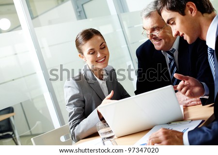 Successful businessteam of three sitting in office and planning work Royalty-Free Stock Photo #97347020