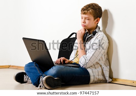 teenager boy is sitting with laptop at school