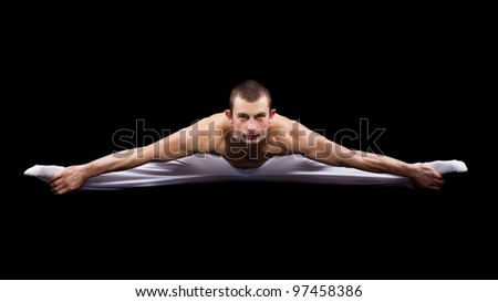 man acrobatics gymnastic doing twine exercise isolated on black background, athletic sportsman