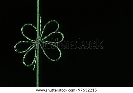 Fancy green ribbon bow isolated on black background with room for your text