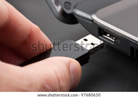 Plugging removable flash disk memory into laptop USB slot Royalty-Free Stock Photo #97680650