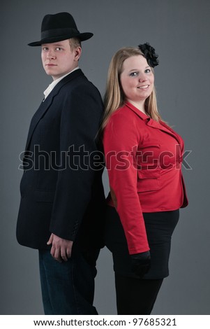 Happy young couple dressed in black and red isolated on grey background