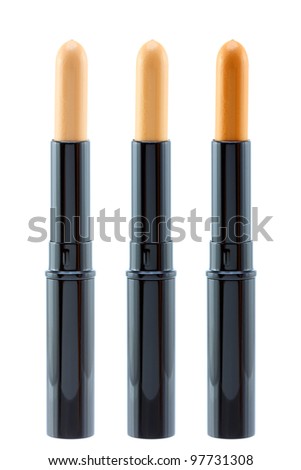 Closeup photo of concealer stick in different shades to conceal under-eye circles or facial blemishes, isolated on white background