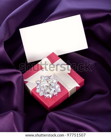 Gift wrapping and ring on a violet background