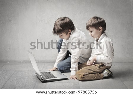 Two little brothers using a laptop