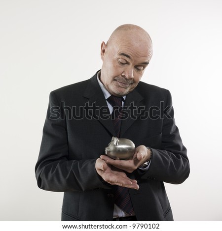 studio portrait isolated on white background of a man senior holding a piggy bank