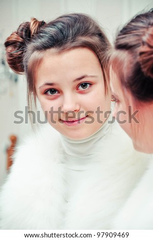 Teen girl in fur vest in mirror reflection