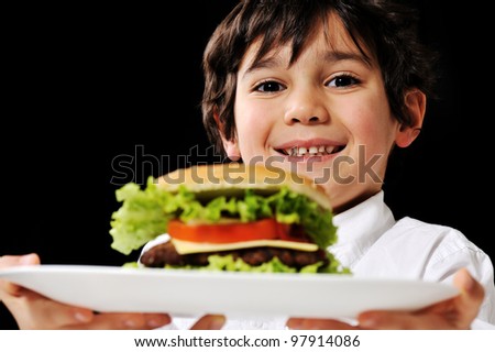 Little boy offering a hamburger on plate