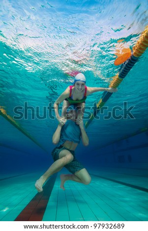 Girl sitting on the boys shoulders - underwater shoot in the pool