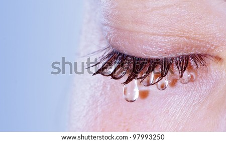 Weeping woman - closeup on eye with teardrop Royalty-Free Stock Photo #97993250
