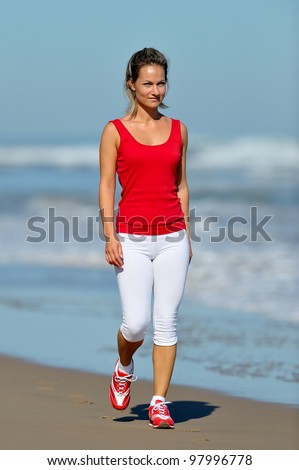  young woman walking on the beach in summer