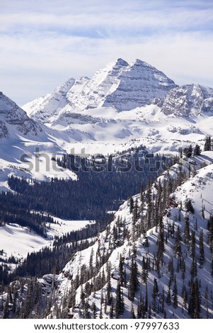 A winter landscape view, in vertical format, of the two peaks in the Maroon Bells massif in Colorado. Royalty-Free Stock Photo #97997633