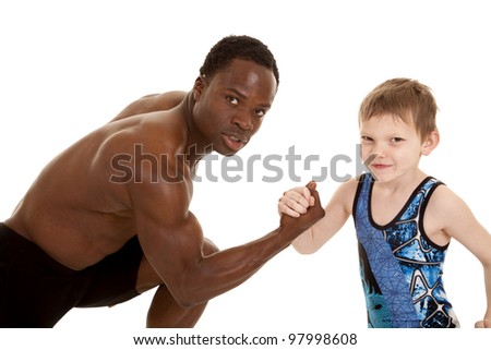 A man and child arm wrestling to see who is stronger.