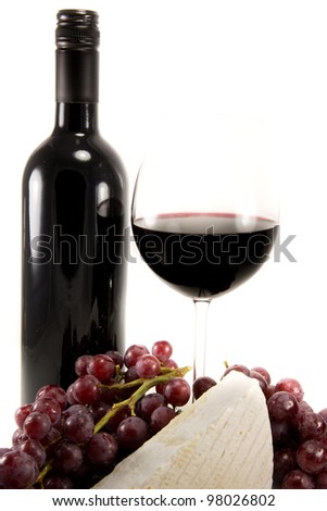 Picture of a bottle of red wine and some brie and a bunch of grapes