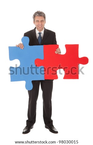 Senior businessman holding a jigsaw puzzle. Isolated in white