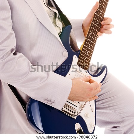 man in white suit playing guitar