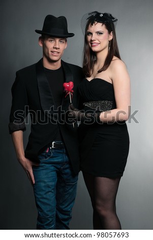 Happy young couple isolated on grey background. Fashion style studio portrait.