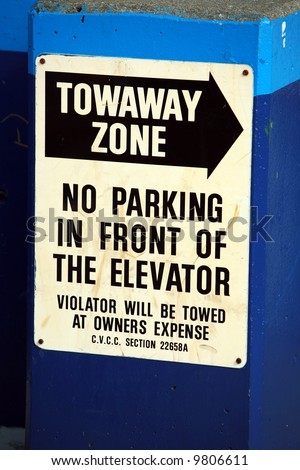a "Towaway Zone" "no parking in front of the elevator" sign