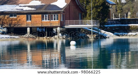 Picture of the hotel on the lake. In the foreground a beautiful reflection of the hotel with an emerald hue, Interlaken, Switzerland