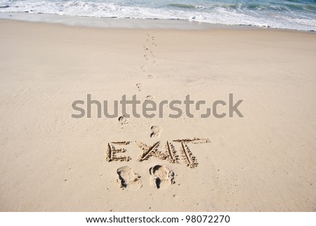traces of man and the word "exit" in the sand,