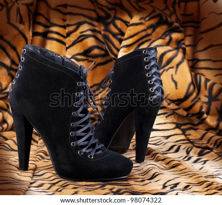Boots from suede against a skin of a tiger