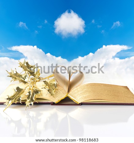 open vintage bible book with golden pages over blue sky background