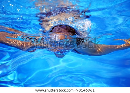 Young girl in transparent blue water, summer background