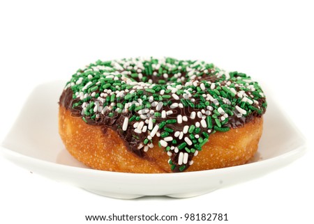   Doughnut with chocolate, cream and sprinkles on the plate  isolated on white background shot in studio