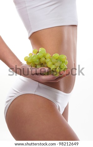 Dieting concept, Beautiful belly and a fruit isolated on white