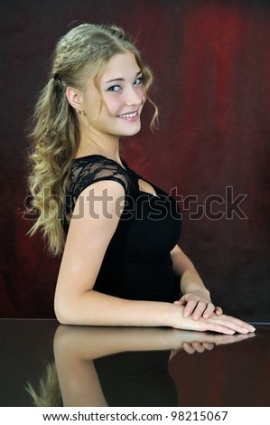 The young woman looking at camera. On a dark red background.