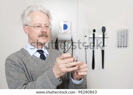 Mature doctor ready to give vaccination with injection at a clinic