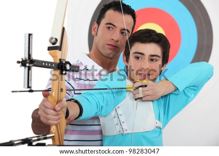 Teenage boy archery lesson Royalty-Free Stock Photo #98283047