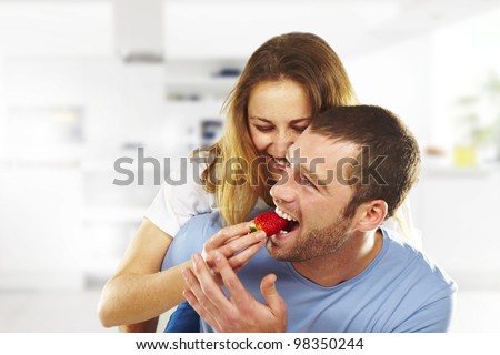 happy young couple eating strawberries together Royalty-Free Stock Photo #98350244