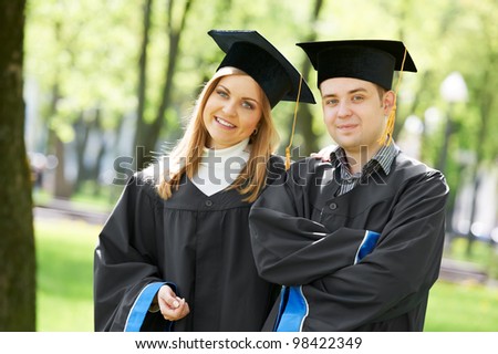 two graduate students guy and girl in mantle laughing at spring park