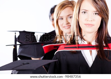 group of female graduates holding graduation caps