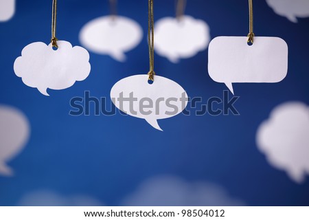Blank white speech bubbles hanging from a cord Royalty-Free Stock Photo #98504012