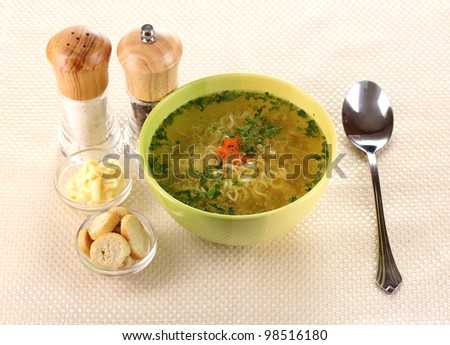 Tasty chicken stock with noodles on beige tablecloth