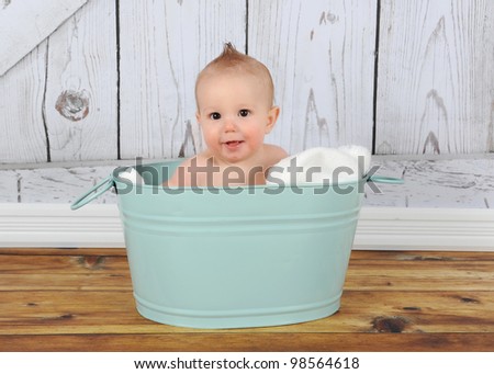 happy baby boy sitting in washtub