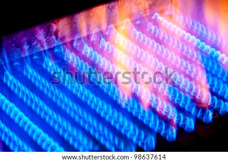 The fire burns from a gas burner inside the boiler. Royalty-Free Stock Photo #98637614