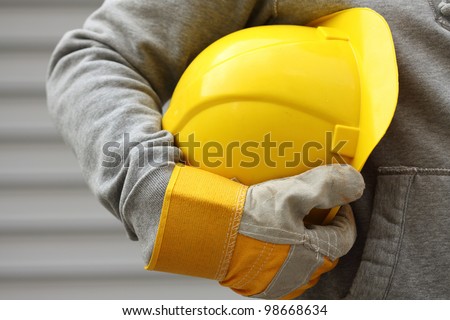 Man holding yellow helmet close up Royalty-Free Stock Photo #98668634