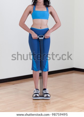 A woman doing fitness exercise with expander at home