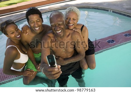 Family Posing for Camera Phone Picture in Pool