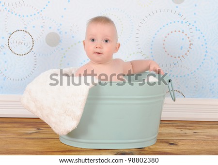 baby boy sitting in washbasin