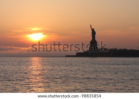 A sunset nearing the Statue of Liberty at dusk.