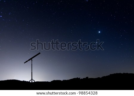 Night shot with a silhouette of a telescope, with a sky full of stars and the conjunction of Venus and Jupiter