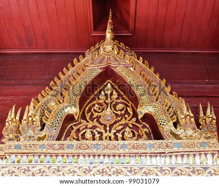 Golden dragon carving on  top of Thai church roof.