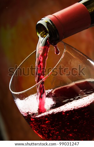 Red wine being poured into wine glass Royalty-Free Stock Photo #99031247