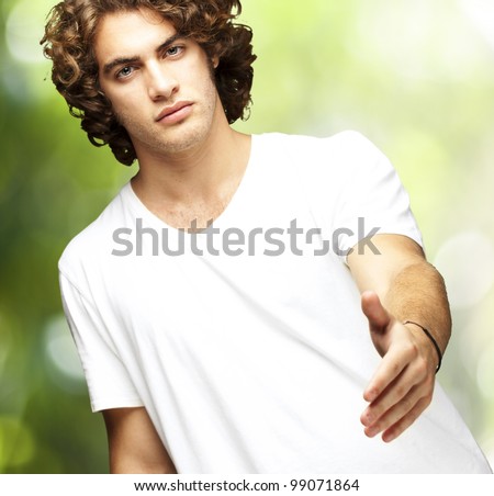 portrait of young man gesturing contract against a nature background