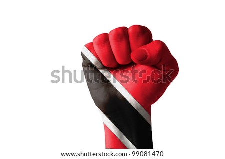Low key picture of a fist painted in colors of trinidad tobago flag