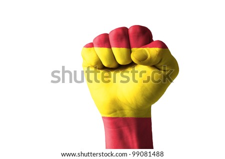 Low key picture of a fist painted in colors of spain flag